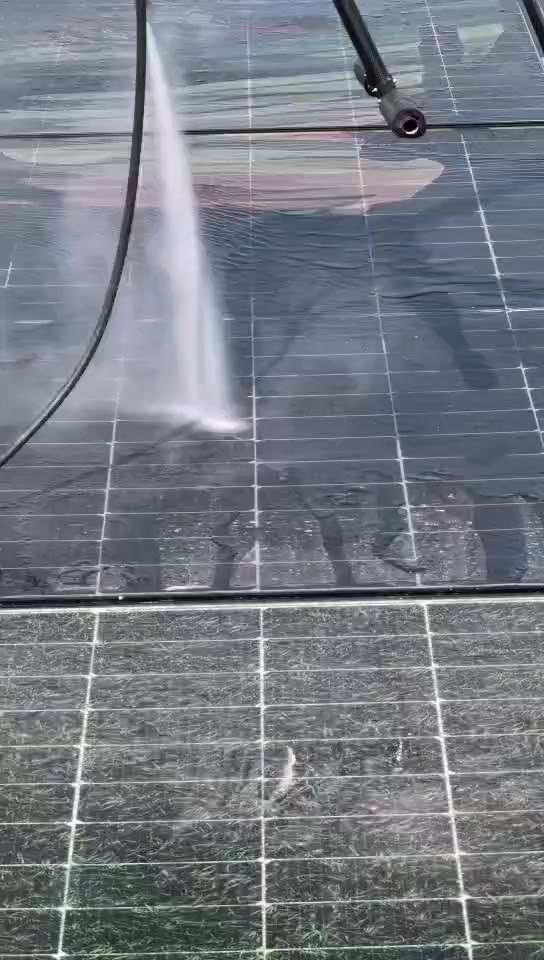 近距離拍攝的面板沖洗畫面，下半部未清洗的面板格線間布滿綠色附著物，上半部已沖洗乾淨。